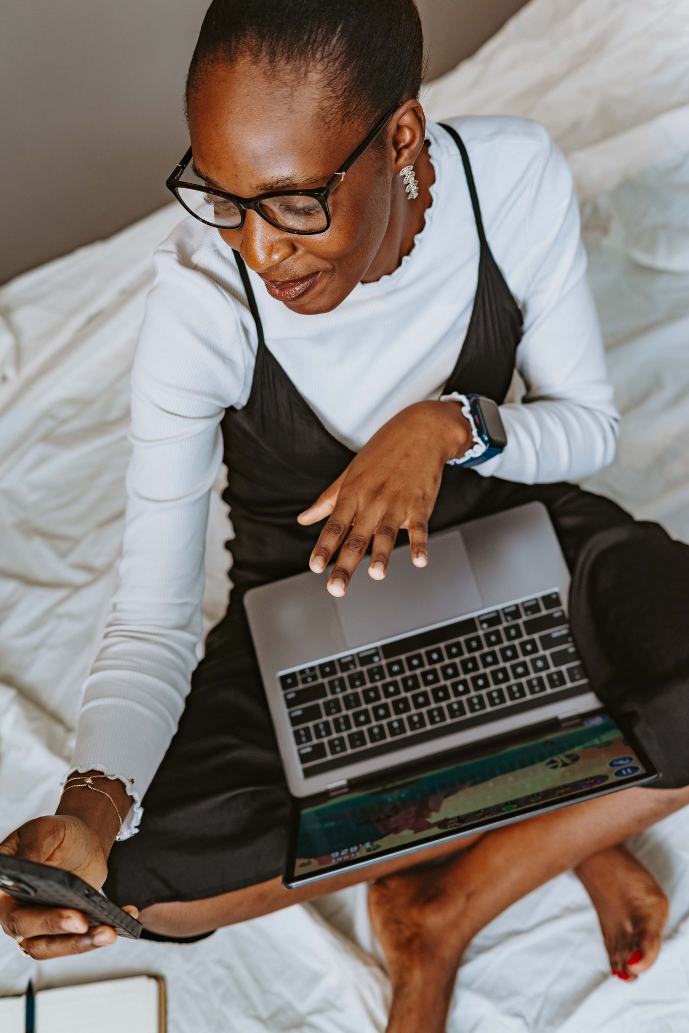 An African woman using a laptop and smartphone in Abuja